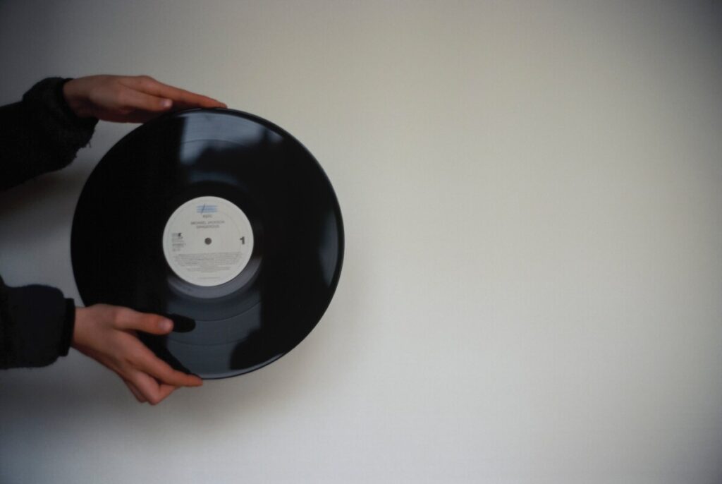black vinyl record held by someone